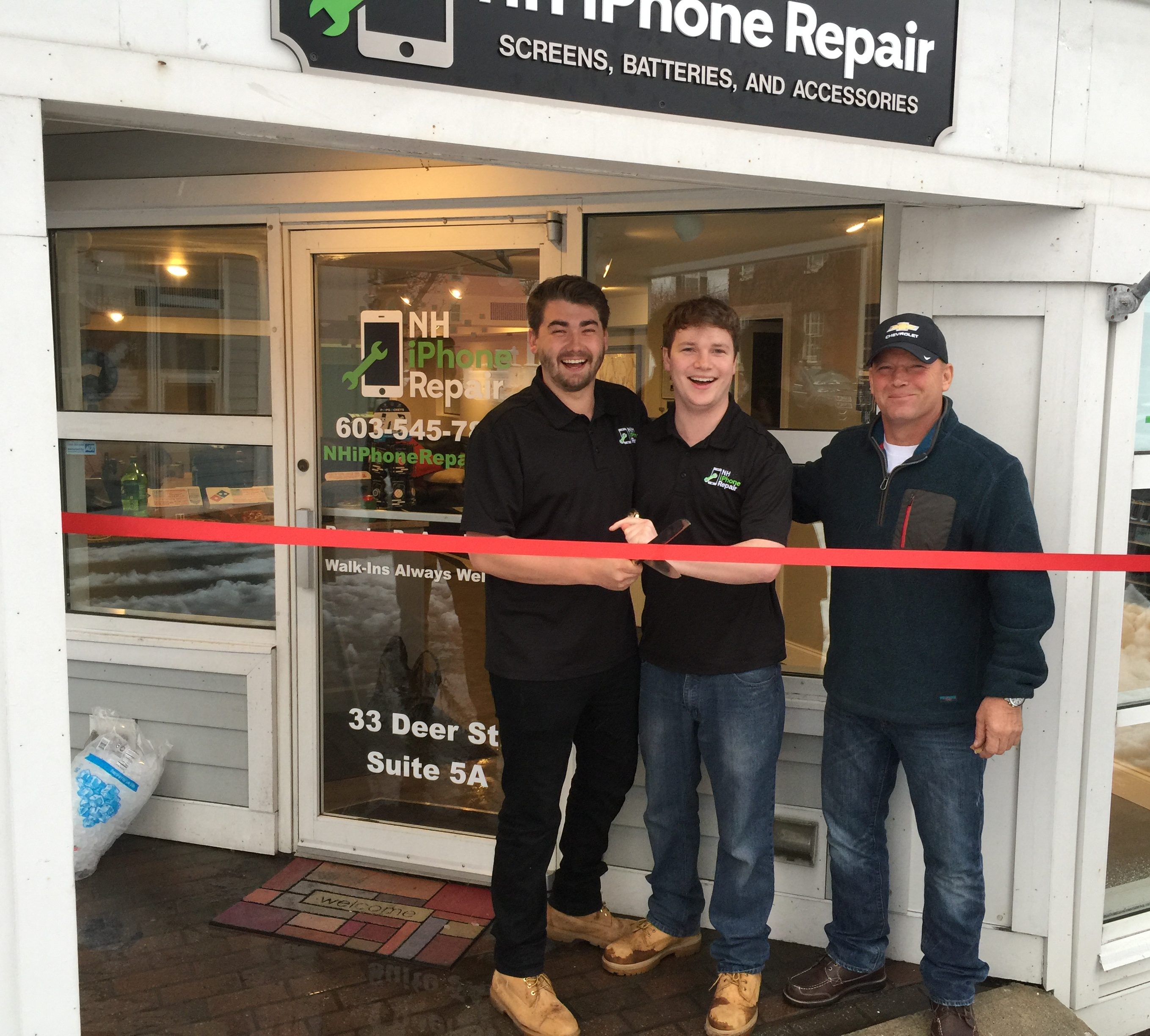 Grand opening of NH iPhone Repair. NH iPhone Repair owners cutting the red ribbon in front of the door